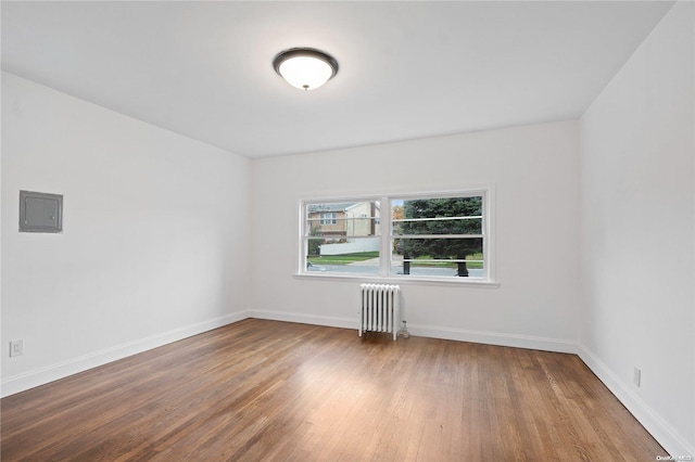 empty room with wood-type flooring and radiator