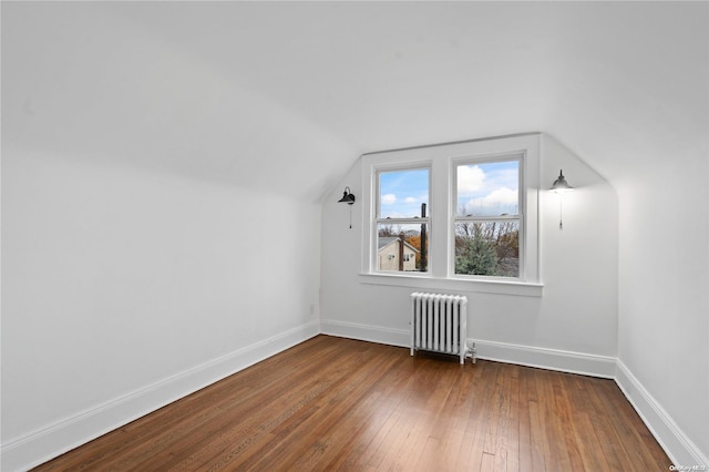 bonus room with hardwood / wood-style floors, vaulted ceiling, and radiator