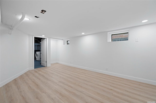 basement with washing machine and dryer and light wood-type flooring