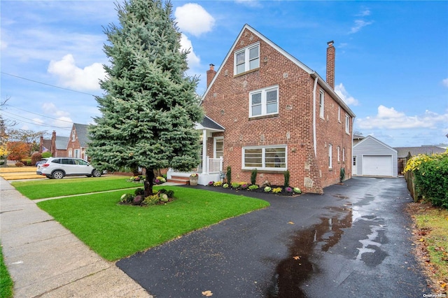 view of front of house featuring an outbuilding, a front lawn, and a garage