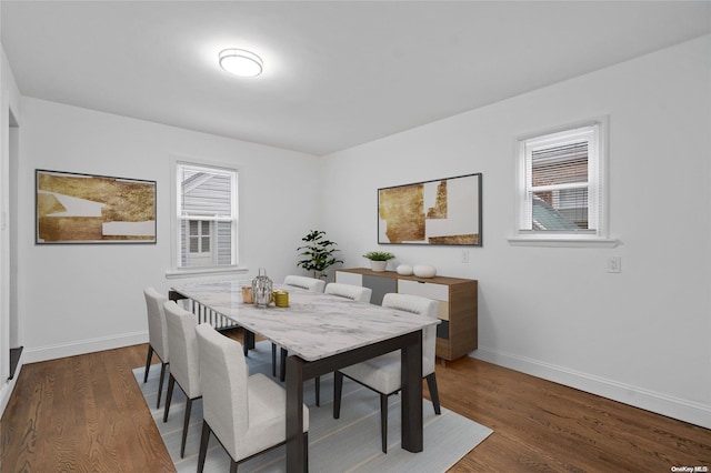 dining space featuring a healthy amount of sunlight and dark wood-type flooring