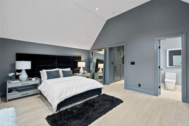 bedroom with ensuite bath, high vaulted ceiling, and light hardwood / wood-style floors