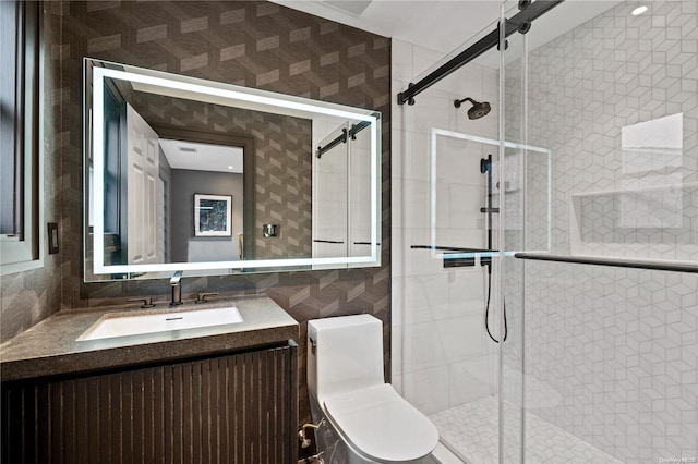 bathroom with vanity, toilet, a shower with shower door, and tile walls