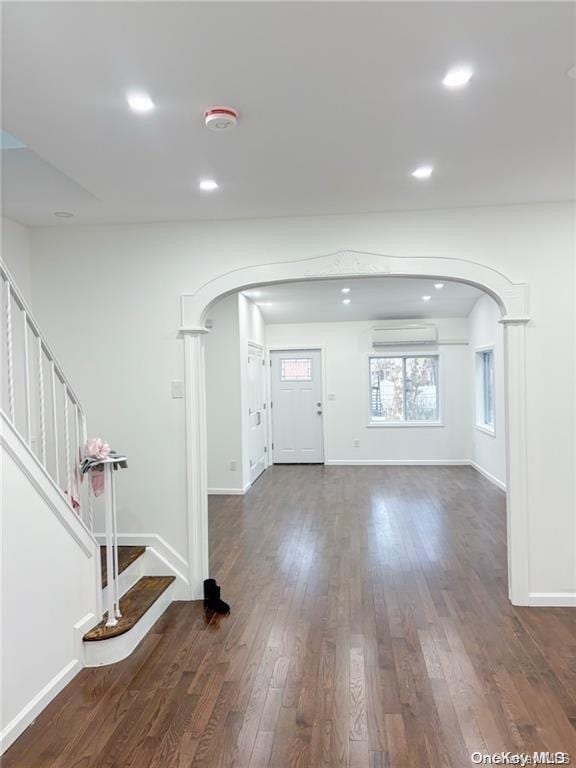 foyer with dark hardwood / wood-style flooring and a wall mounted AC