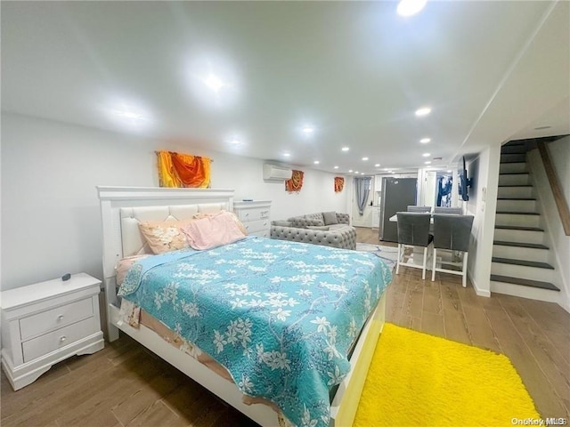 bedroom with a wall unit AC and hardwood / wood-style flooring