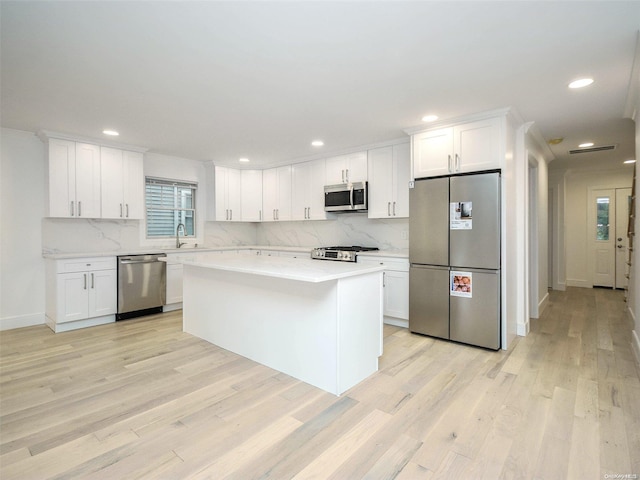 kitchen featuring light hardwood / wood-style floors, a kitchen island, white cabinetry, and stainless steel appliances