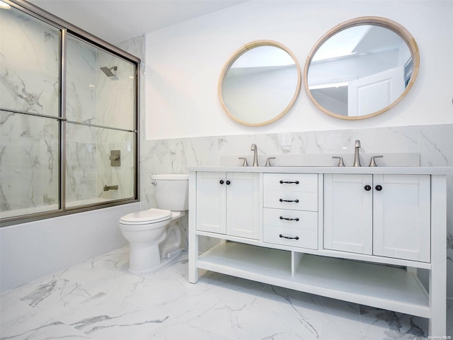 full bathroom featuring vanity, toilet, tile walls, and bath / shower combo with glass door