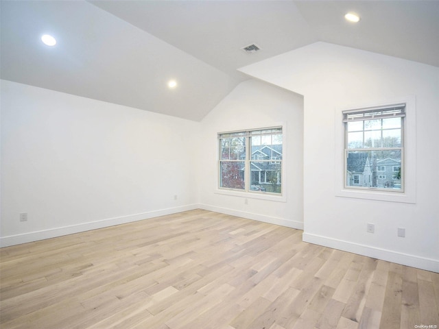 unfurnished room featuring light wood-type flooring and vaulted ceiling