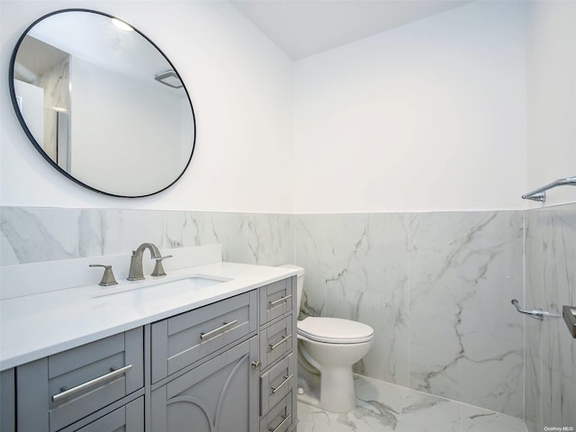 bathroom with vanity, tile walls, and toilet