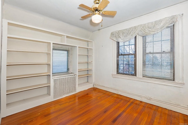 spare room featuring hardwood / wood-style flooring, radiator, and ceiling fan