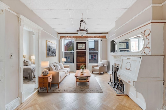 sitting room with a paneled ceiling and light parquet flooring