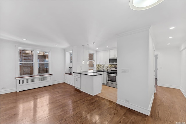 kitchen featuring white cabinetry, radiator heating unit, stainless steel appliances, kitchen peninsula, and light hardwood / wood-style floors