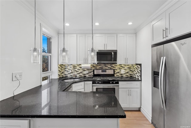 kitchen with kitchen peninsula, white cabinetry, stainless steel appliances, and decorative light fixtures