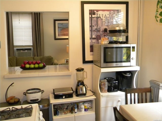 interior space with white stove, tile counters, and cooling unit