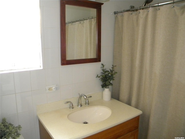 bathroom with vanity, tile walls, and tasteful backsplash