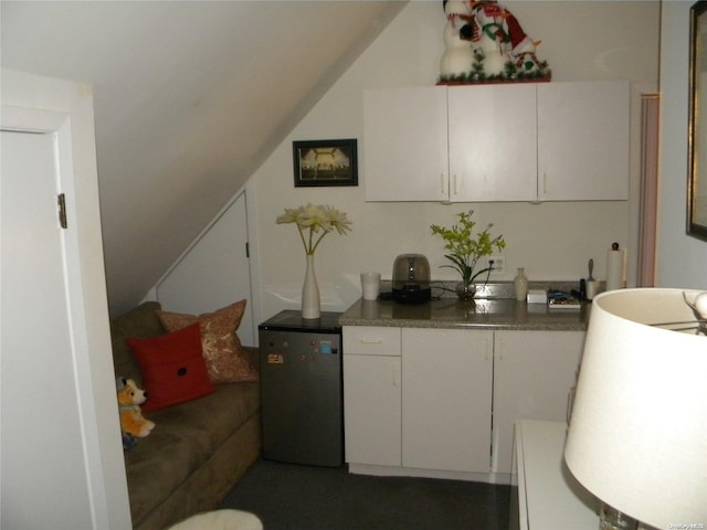 kitchen featuring white cabinetry and stainless steel refrigerator