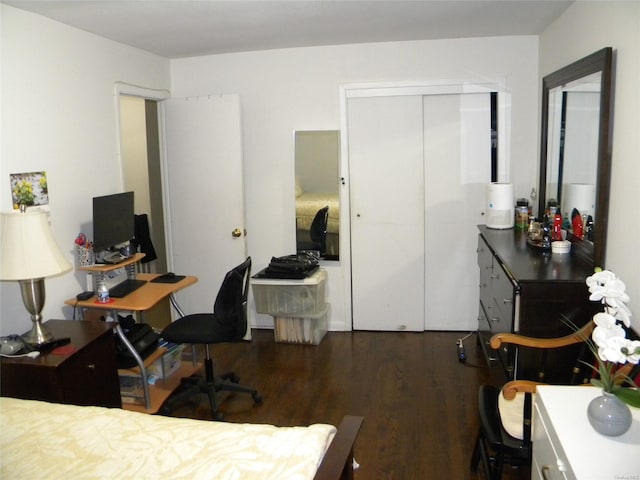 bedroom with dark hardwood / wood-style flooring and a closet