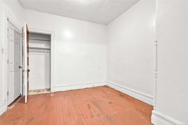 unfurnished bedroom with a closet and hardwood / wood-style floors