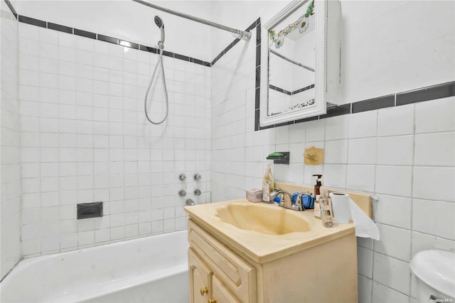 full bathroom with vanity, toilet, tile walls, and tiled shower / bath combo