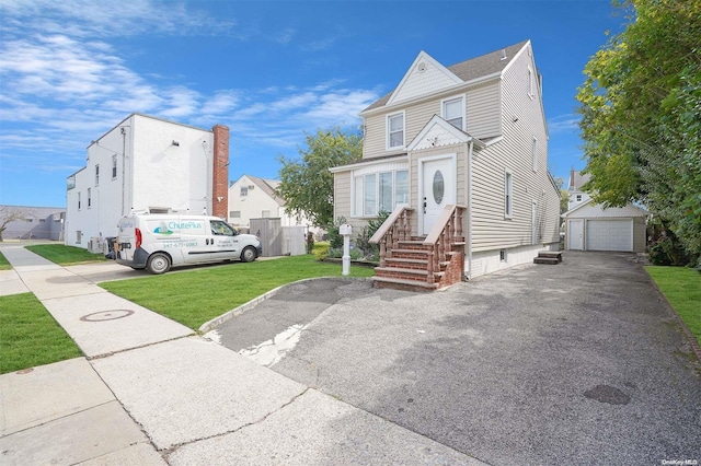 view of front facade featuring a garage, an outbuilding, and a front yard