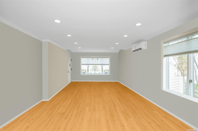 empty room featuring light hardwood / wood-style flooring, a wall mounted AC, and crown molding