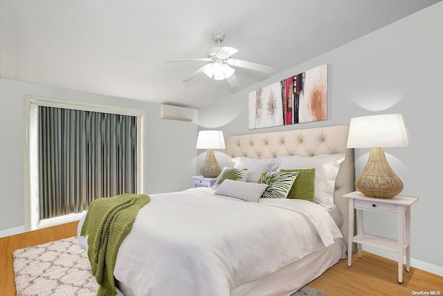 bedroom with wood-type flooring, a wall mounted AC, and ceiling fan