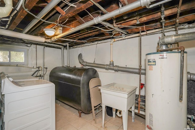 basement featuring light tile patterned floors, washer and clothes dryer, and water heater