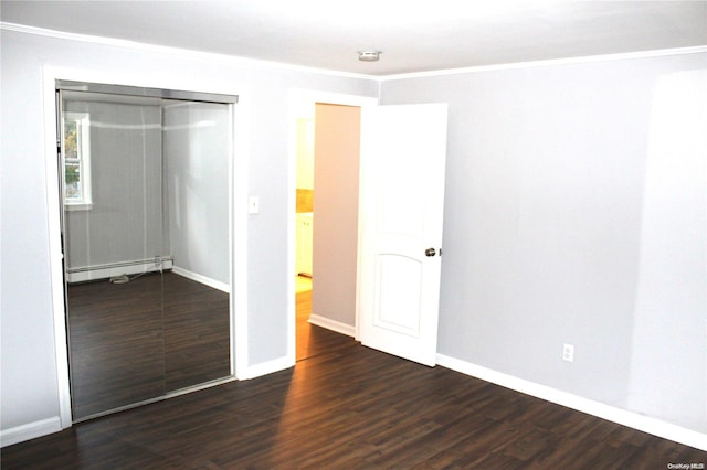 unfurnished bedroom featuring a baseboard radiator, crown molding, a closet, and dark wood-type flooring