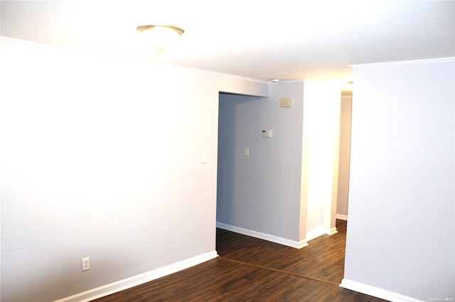 spare room with dark hardwood / wood-style flooring and crown molding