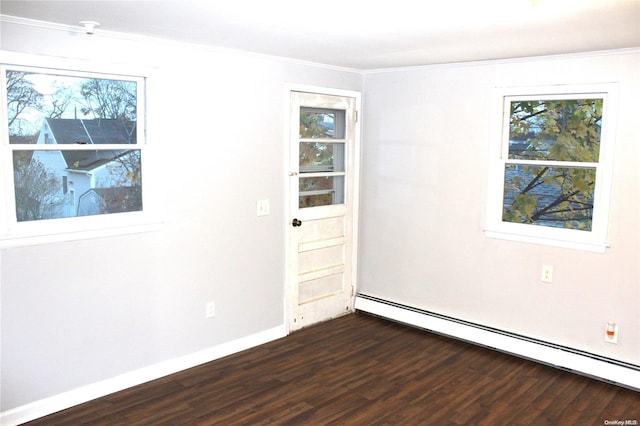 empty room with ornamental molding, dark hardwood / wood-style floors, and a baseboard heating unit