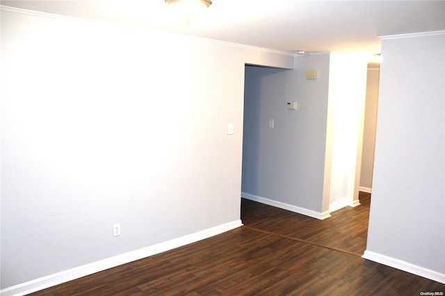 empty room with ornamental molding and dark wood-type flooring