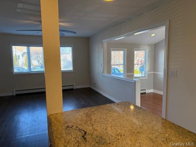 interior space featuring a baseboard radiator, ceiling fan, and dark wood-type flooring