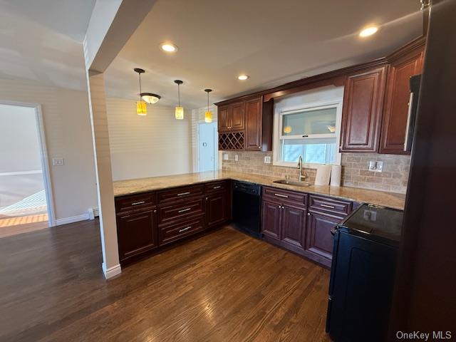 kitchen featuring backsplash, dark wood-type flooring, black appliances, sink, and decorative light fixtures