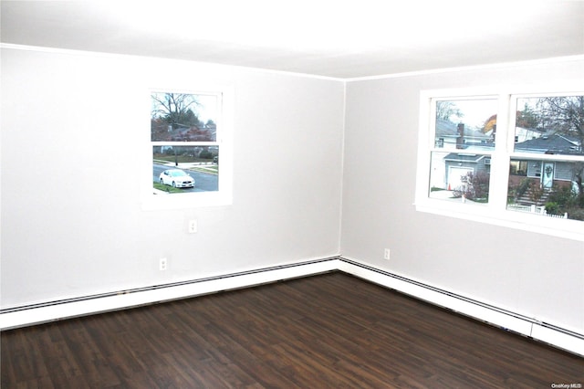 empty room featuring ornamental molding, wood-type flooring, and a baseboard heating unit