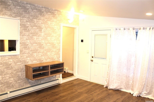 interior space featuring a baseboard radiator, vaulted ceiling, dark wood-type flooring, and brick wall