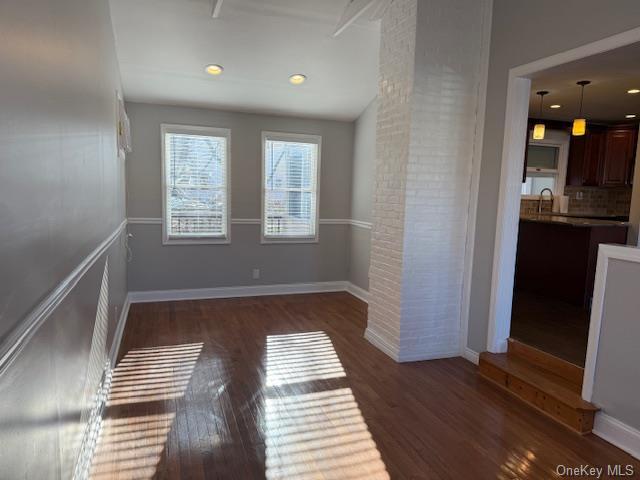 unfurnished room with dark hardwood / wood-style flooring, ornate columns, sink, and vaulted ceiling