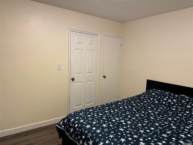 bedroom with dark hardwood / wood-style floors