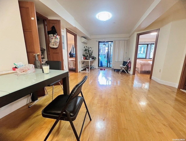 interior space with a wall mounted AC and light hardwood / wood-style floors