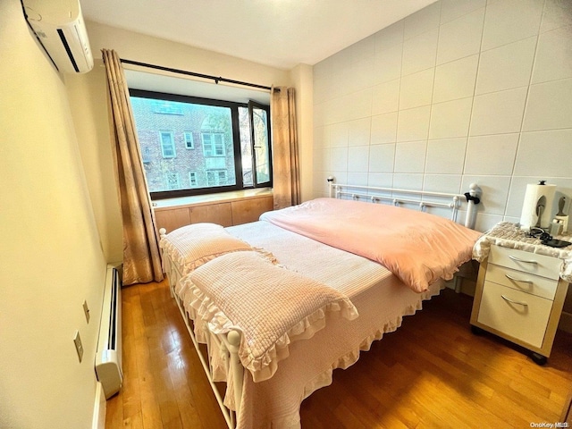 bedroom with wood-type flooring, baseboard heating, an AC wall unit, and tile walls