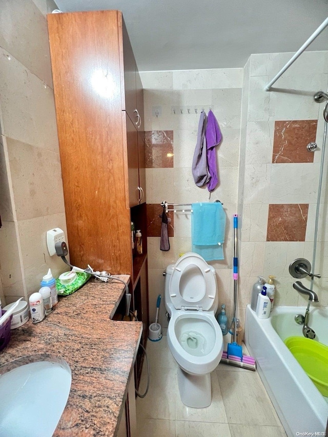 full bathroom featuring vanity, tile walls, tile patterned flooring, toilet, and tiled shower / bath