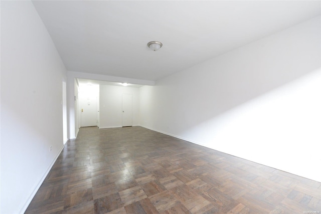 unfurnished room with dark parquet flooring