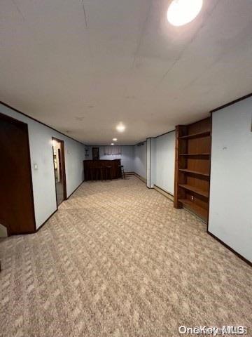 basement featuring light carpet