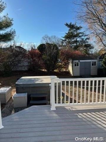 deck with a storage unit and a hot tub