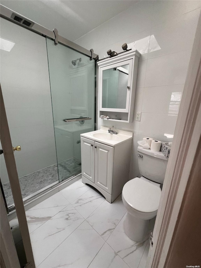 bathroom with vanity, an enclosed shower, tile walls, and toilet