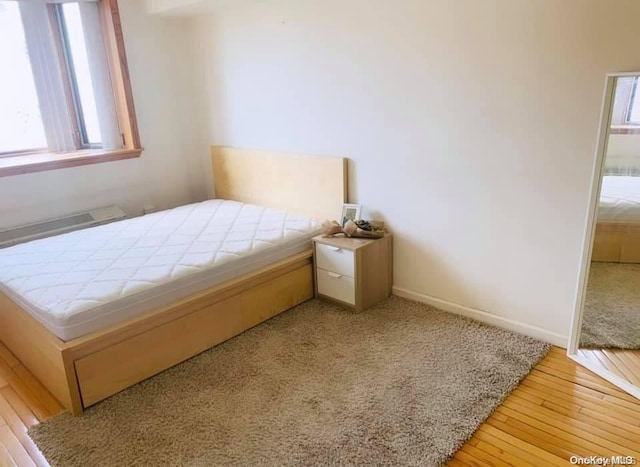 bedroom with light hardwood / wood-style floors and multiple windows