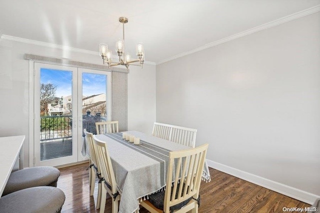 dining area with dark hardwood / wood-style floors, an inviting chandelier, and ornamental molding