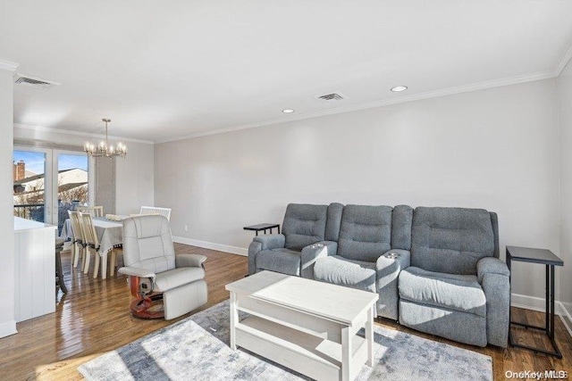 living room with crown molding, a chandelier, and wood-type flooring