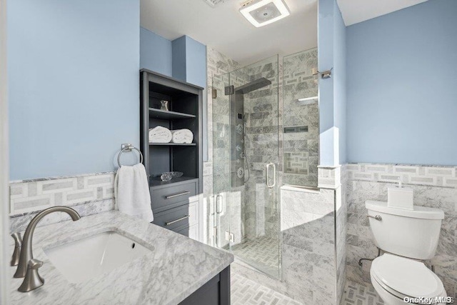 bathroom with walk in shower, vanity, tile walls, and toilet