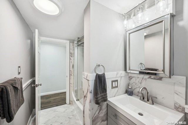 bathroom featuring hardwood / wood-style floors, vanity, and a shower with door