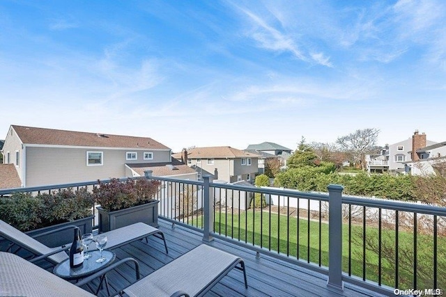 wooden deck featuring a lawn